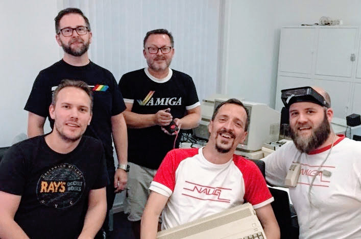 Guys in Amiga T-shirts in white room.